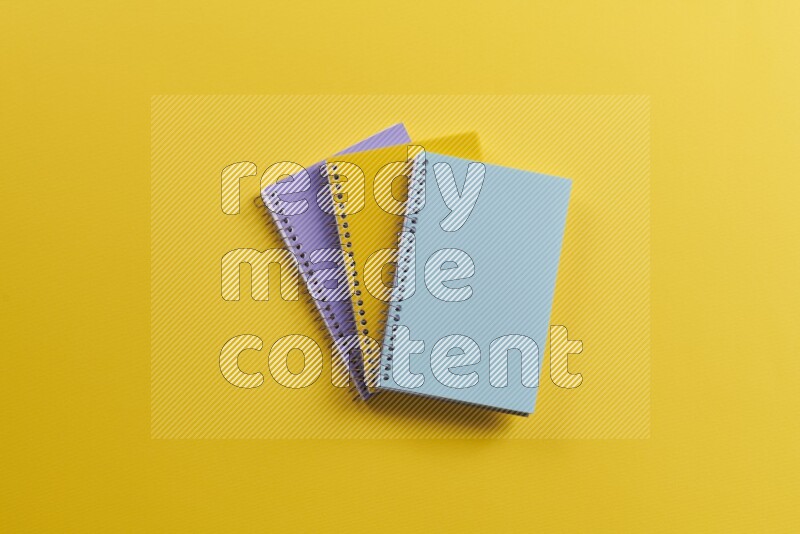 Multicolored notebooks on yellow background