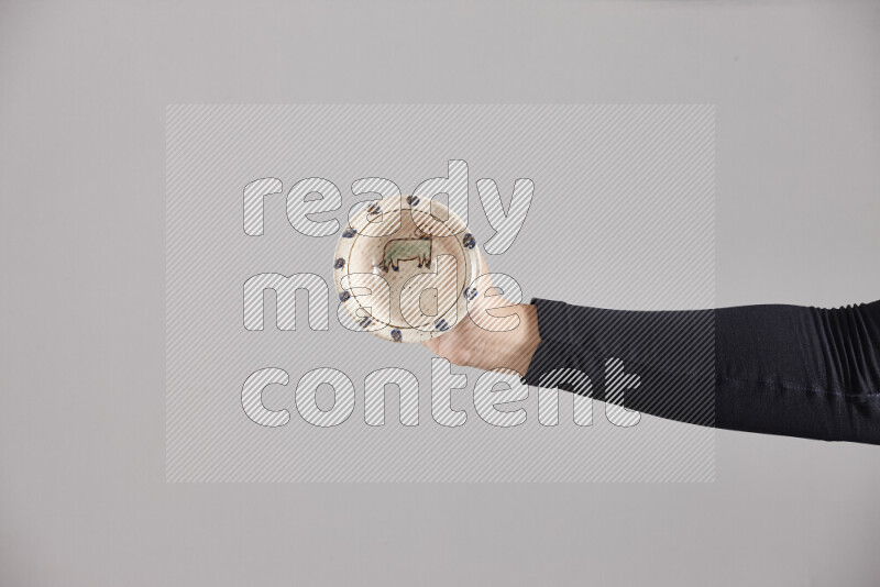 A woman in black abaya holding different pottery essentials in different positions