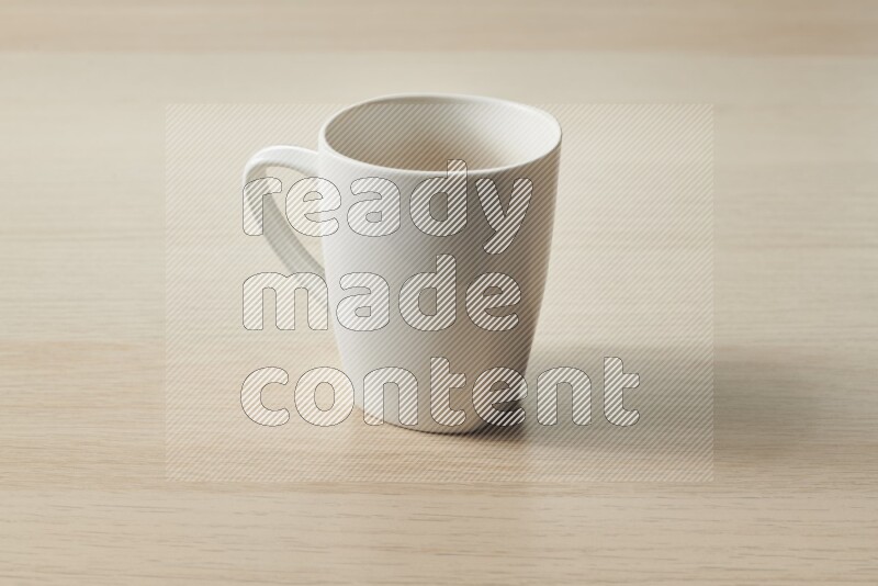 A white ceramic mug on light wooden background
