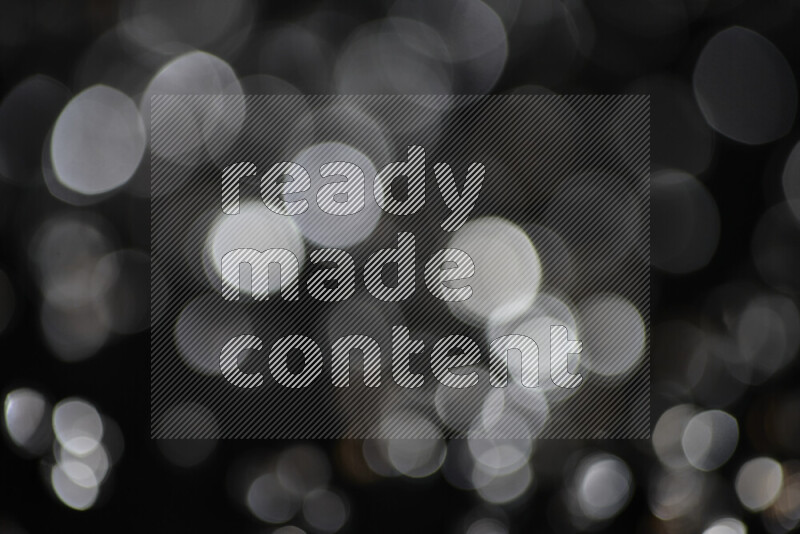 Silver shimmering fragments of glass scattered on a black background