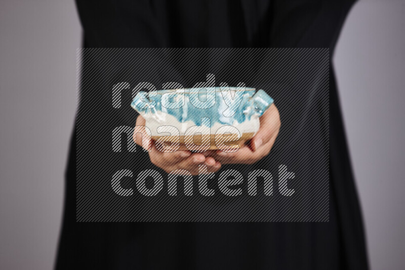 A woman in black abaya holding different pottery essentials in different positions