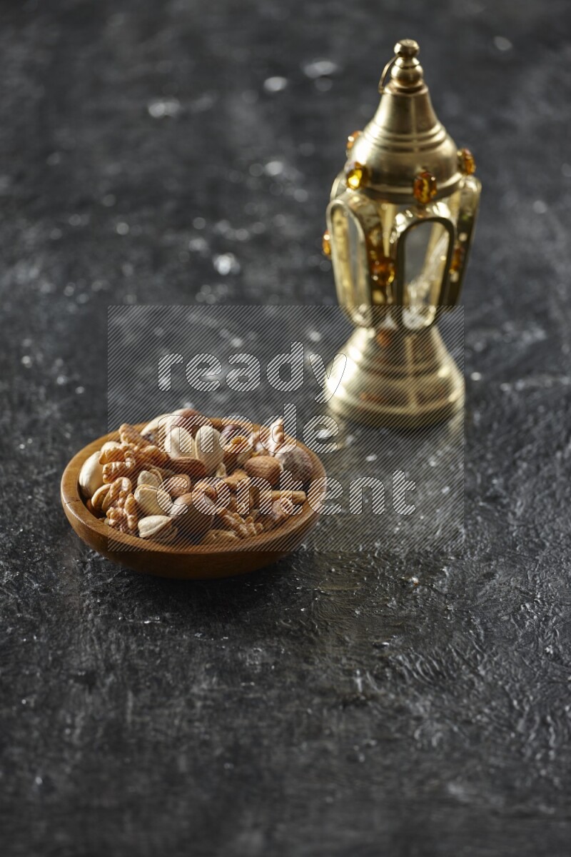 A golden lantern with different drinks, dates, nuts, prayer beads and quran on textured black background