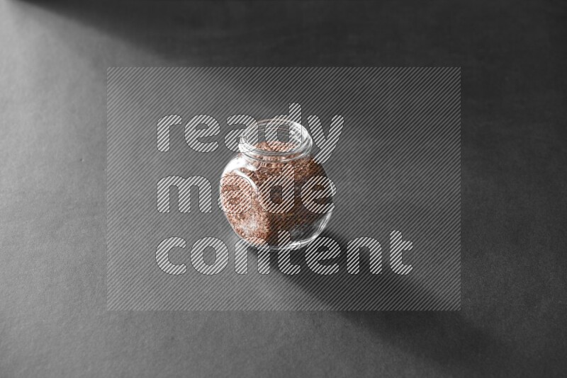 حبوب الكتان في وعاء زجاجي علي خلفية سوداء