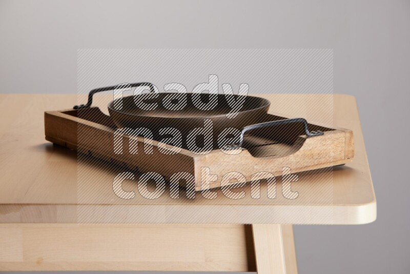 brass bowl on a light colored rectangular wooden tray with handles