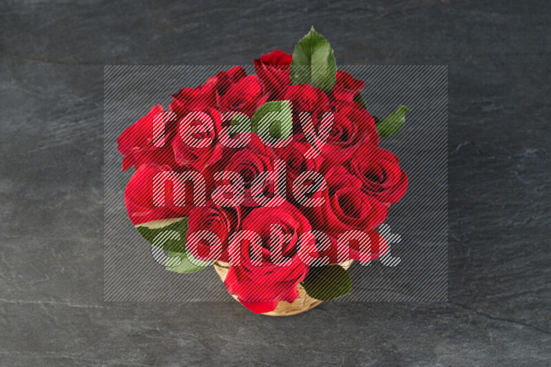 Vibrant red roses in a wicker basket on black marble background