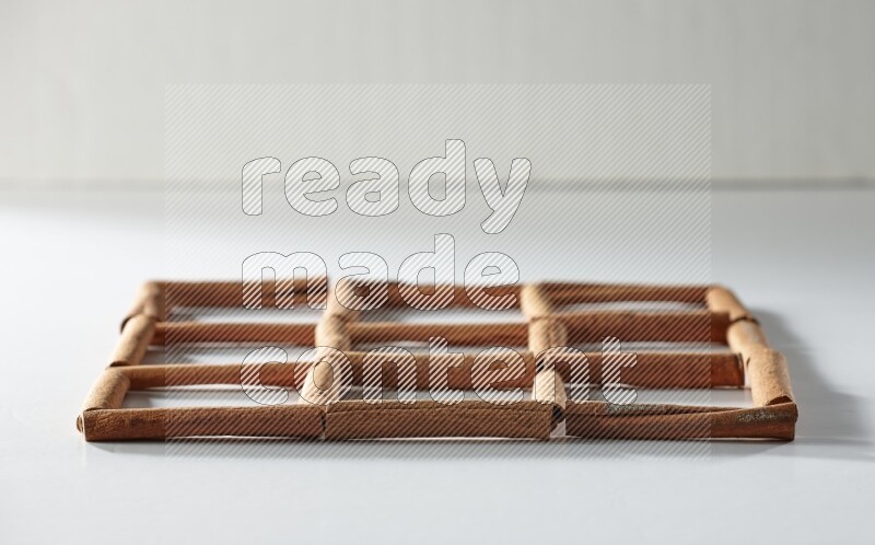 9 مربعات فارغة من أعواد القرفة على أرضية بيضاء