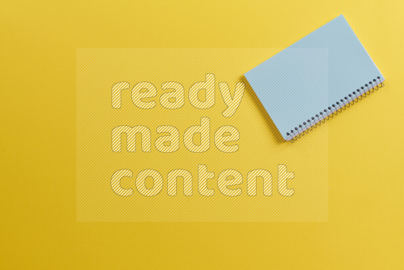 دفتر ملاحظات أزرق مع مستلزمات مدرسية مختلفة على خلفية صفراء