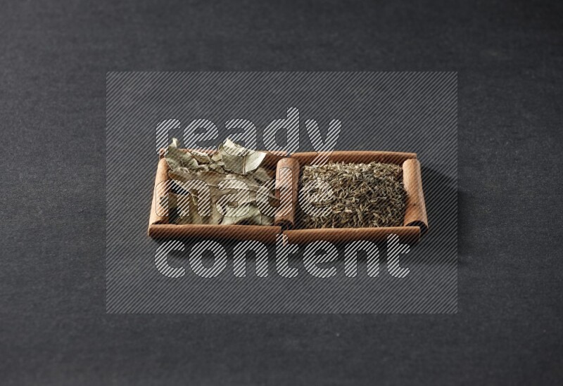 2 squares of cinnamon sticks full of cumin and bay laurel leaves on black flooring