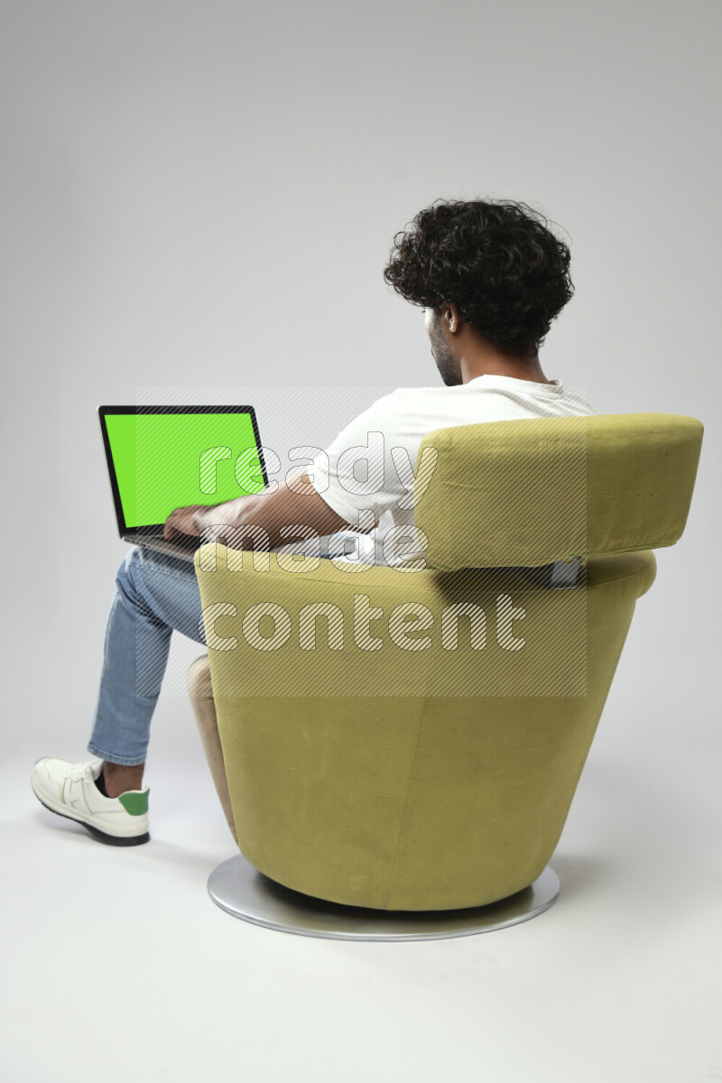 A man wearing casual sitting on a chair showing a laptop screen on white background