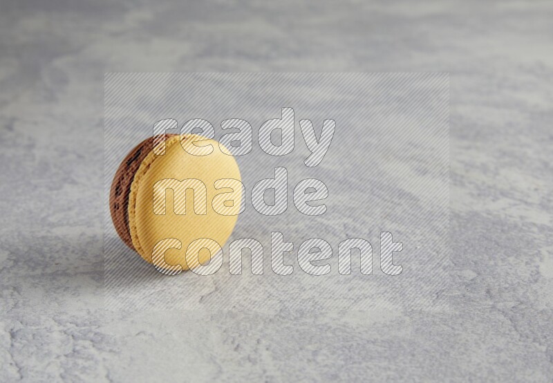 45º Shot of Yellow and Brown Chai Latte macaron on white  marble background