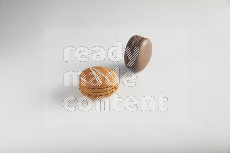 45º Shot of of two assorted Brown Irish Cream, and Brown Dark Chocolate macarons on white background