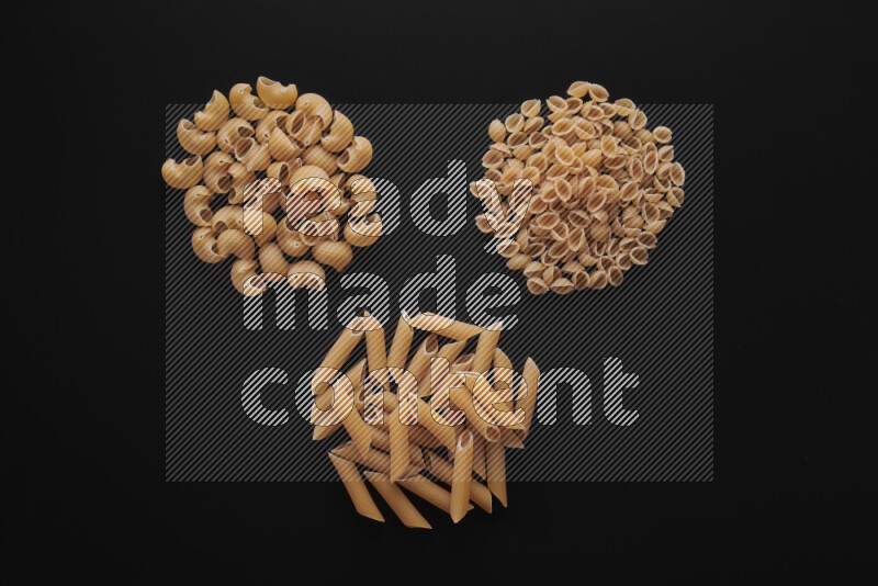 Different pasta types in bunches on black background