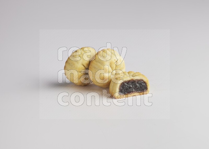 Three Pieces of Maamoul filled with date one of them is cut direct on white background