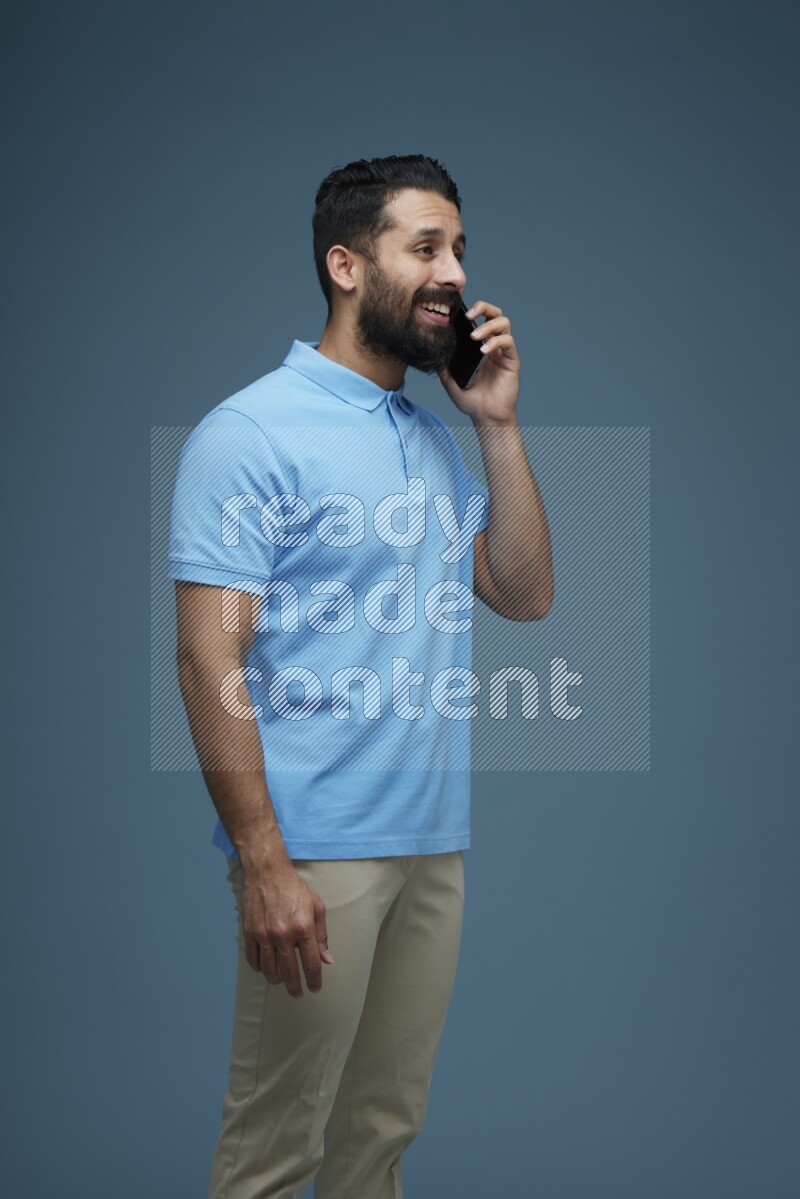 A man having a Call in a blue background wearing a Blue shirt