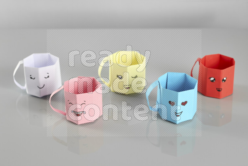 Origami cup on grey background