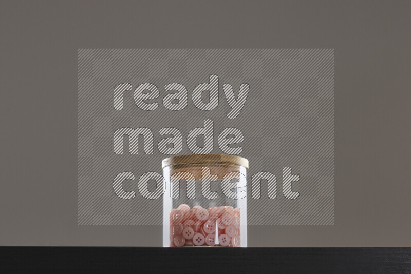 Buttons in a glass jar on black background
