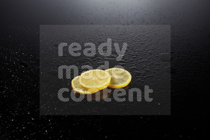 Lemon slices with water drops, and droplets on black background