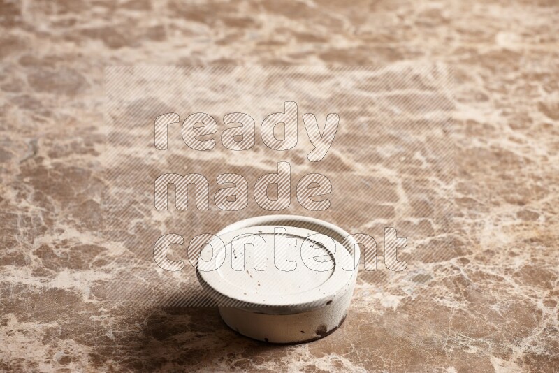A white pottery bowl on beige marble background