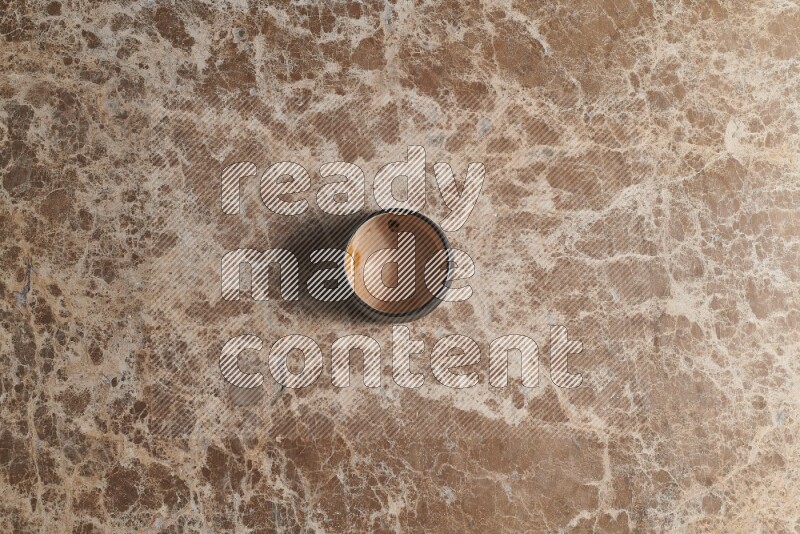 A multicolored pottery bowl on beige marble background