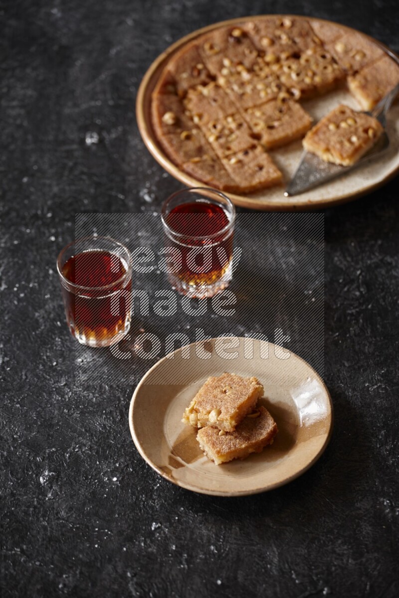 بسبوسة مع الشاي علي خلفية سوداء خشبية