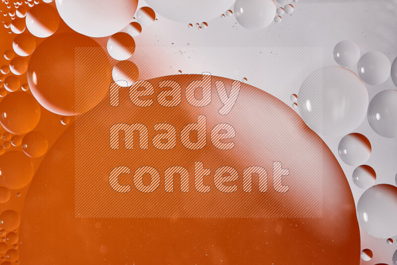 لقطات مقربة لفقاعات من الزيت على سطح الماء باللون الأبيض والبرتقالي