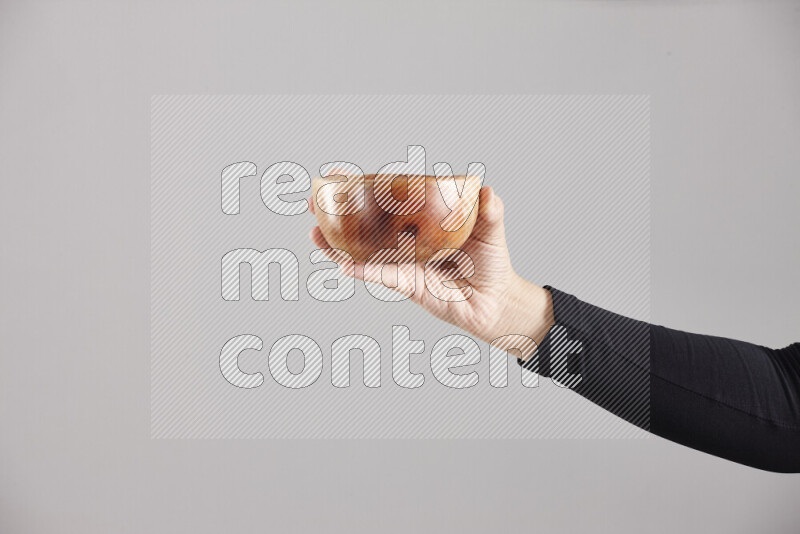 A woman in black abaya holding different wooden essentials in different positions