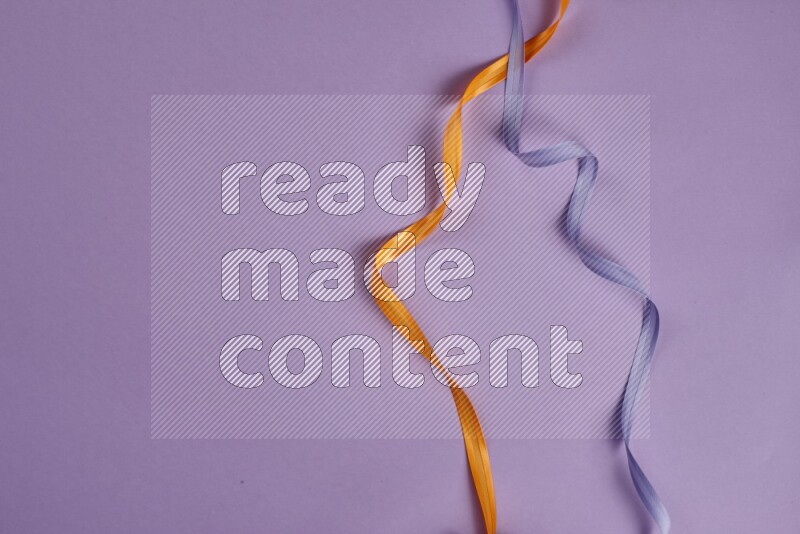 مجموعة من أدوات الخياطة والتفصيل برتقالية اللون على خلفية أرجوانية