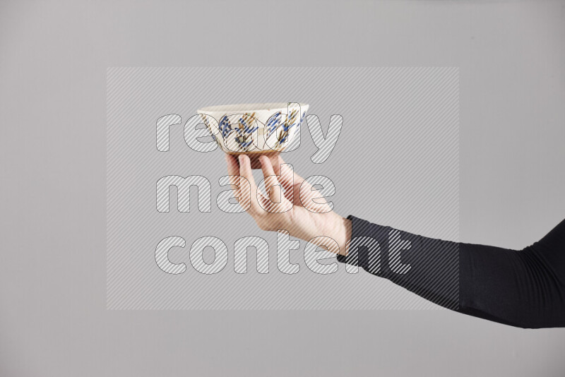 A woman in black abaya holding different pottery essentials in different positions