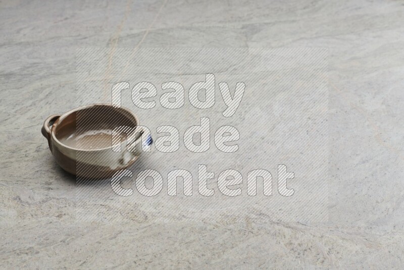 A multicolored pottery bowl on grey marble background