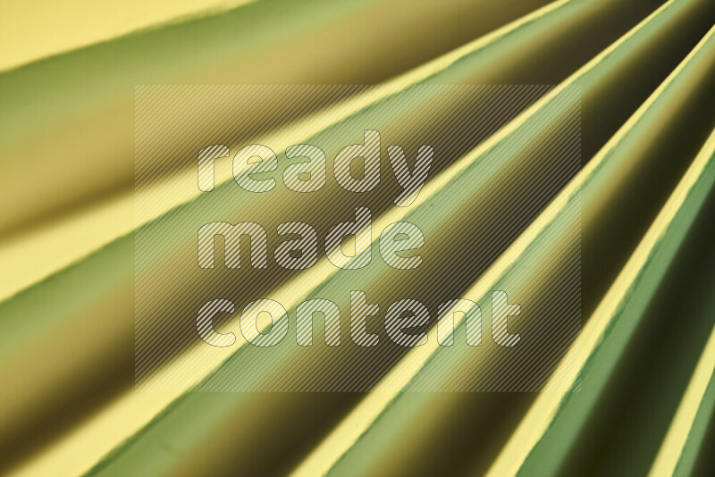 An image presenting an abstract paper pattern of lines in green and gold tones