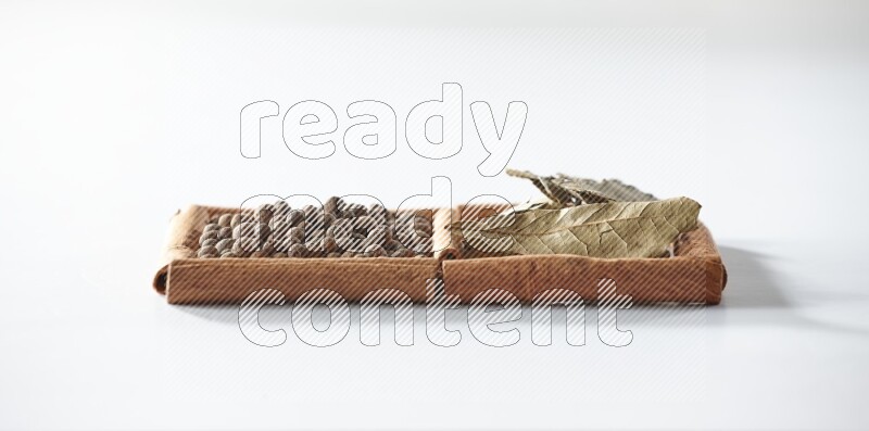 2 squares of cinnamon sticks full of allspice and bay laurel leaves on white flooring