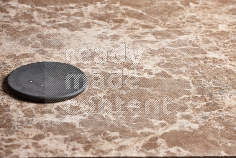A pottery coaster on beige marble background