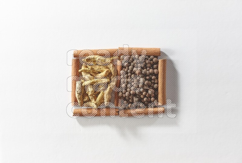 2 squares of cinnamon sticks full of allspice and turmeric fingers on white flooring