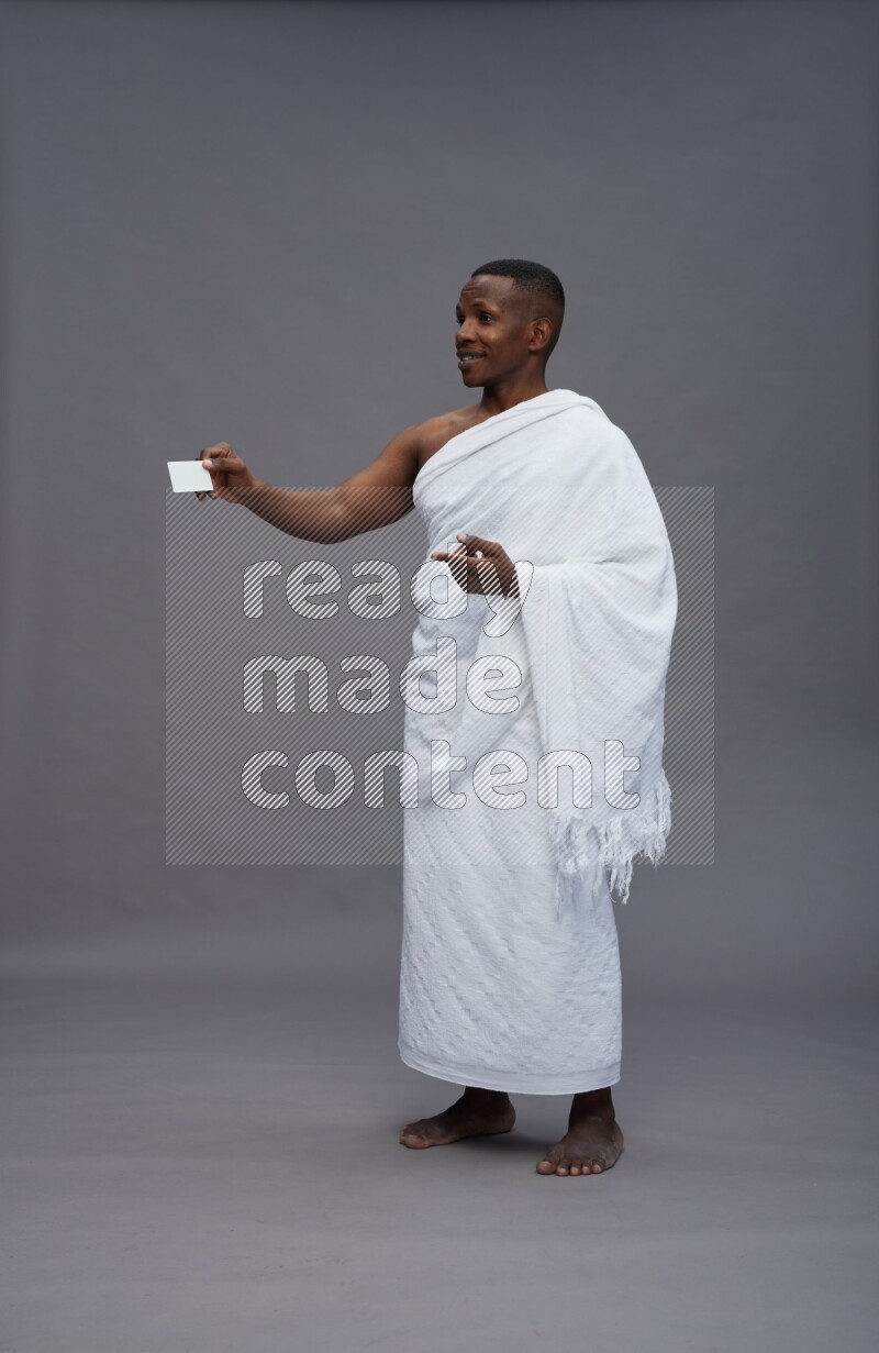 A man wearing Ehram Standing holding ATM card on gray background