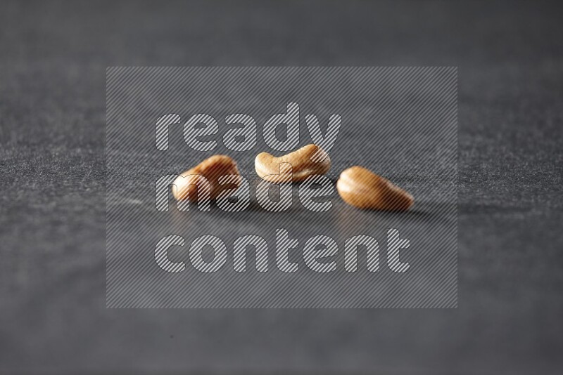 3 cashews on a black background in different angles