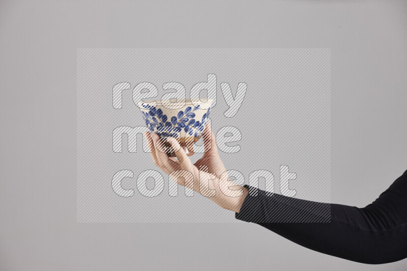A woman in black abaya holding different pottery essentials in different positions
