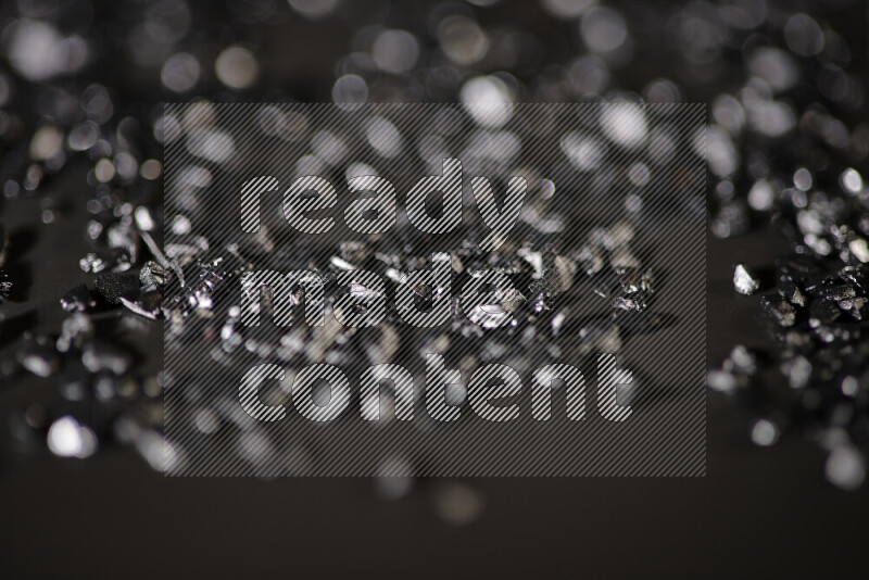 قطع زجاجية سوداء لامعة متناثرة على خلفية سوداء