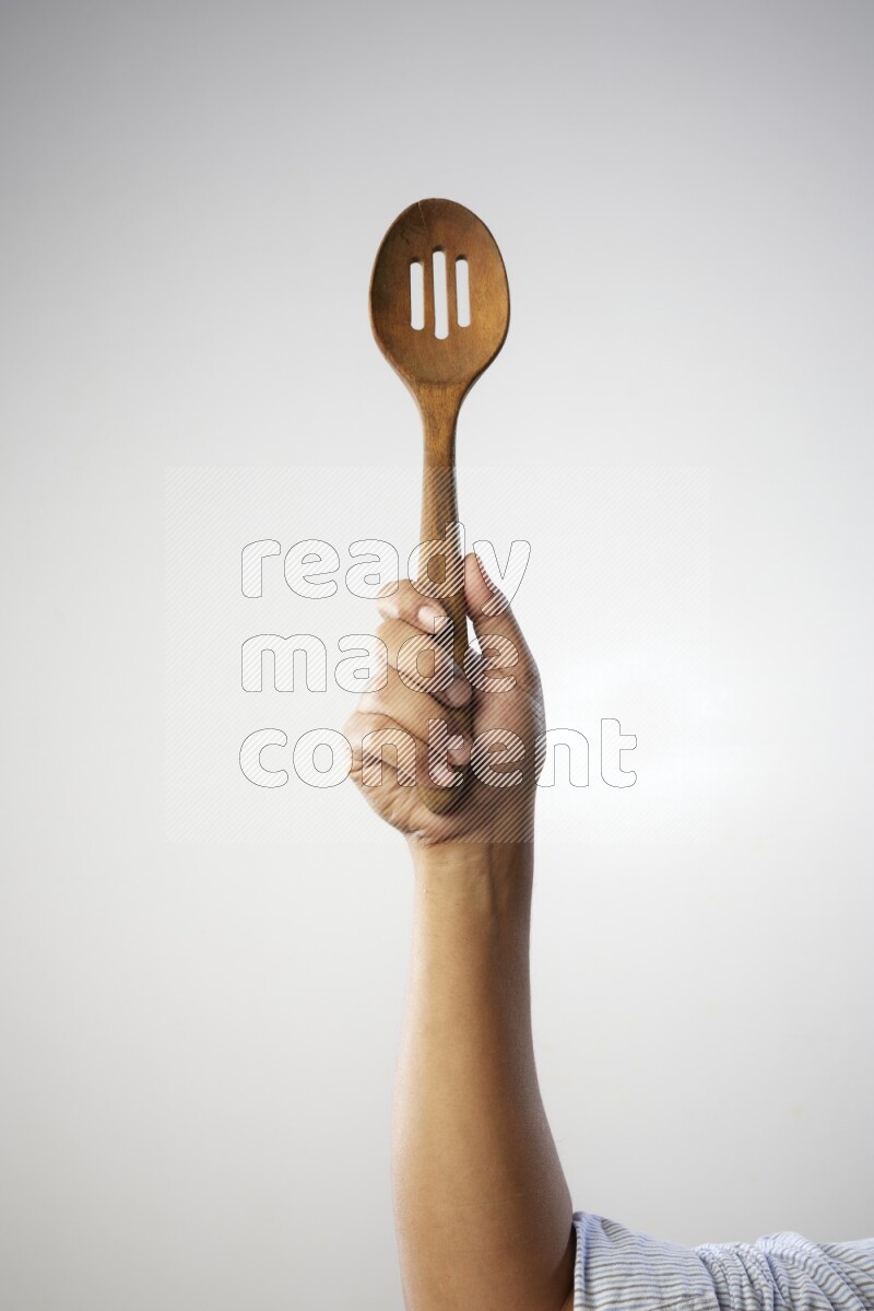 Male Hand Holding Wooden colander spoon  on white background