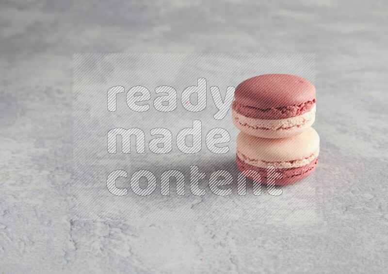 45º Shot of two Pink Litchi Raspberry macarons  on white  marble background