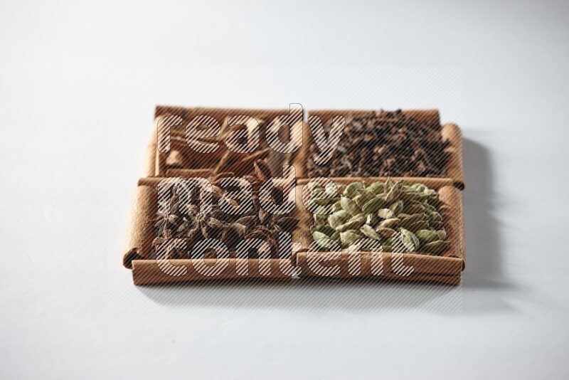 4 squares of cinnamon sticks full of cardamom, star anise, cloves and cinnamon on white flooring