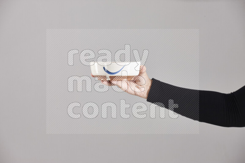 A woman in black abaya holding different pottery essentials in different positions