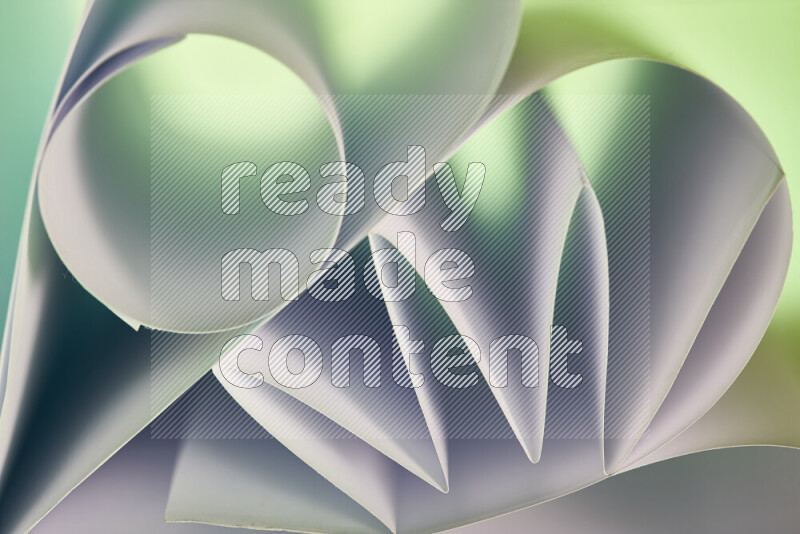 An artistic display of paper folds creating a harmonious blend of geometric shapes, highlighted by soft lighting in green and red tones