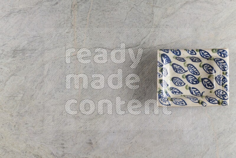 A decorative pottery plate on grey marble background