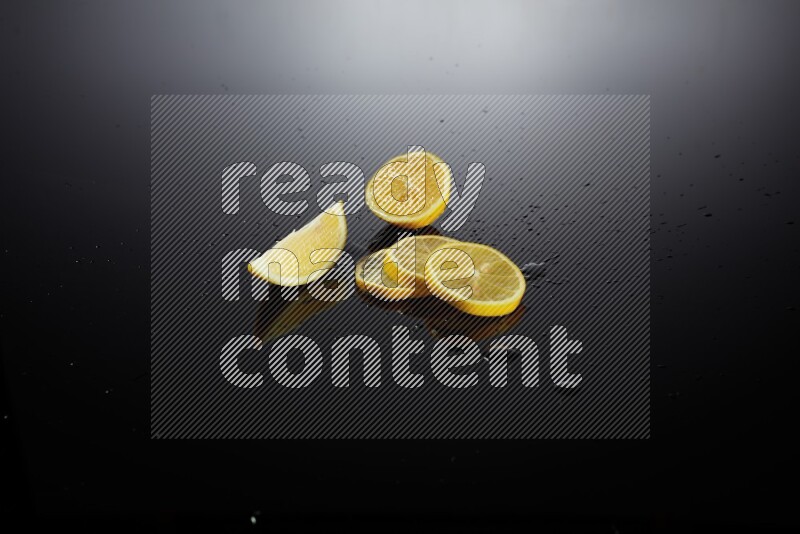 Lemon slices with water drops, and droplets on black background