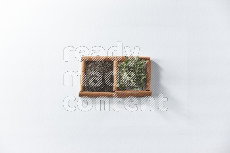 2 squares of cinnamon sticks full of black tea and dried mint leaves on white flooring