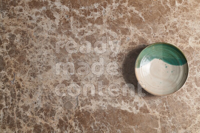 A decorative pottery plate on beige marble background
