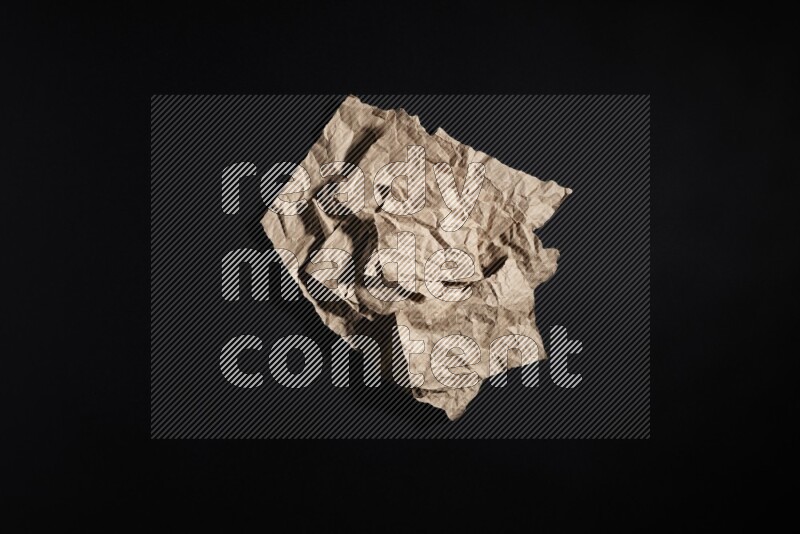 Crumpled craft paper on black background