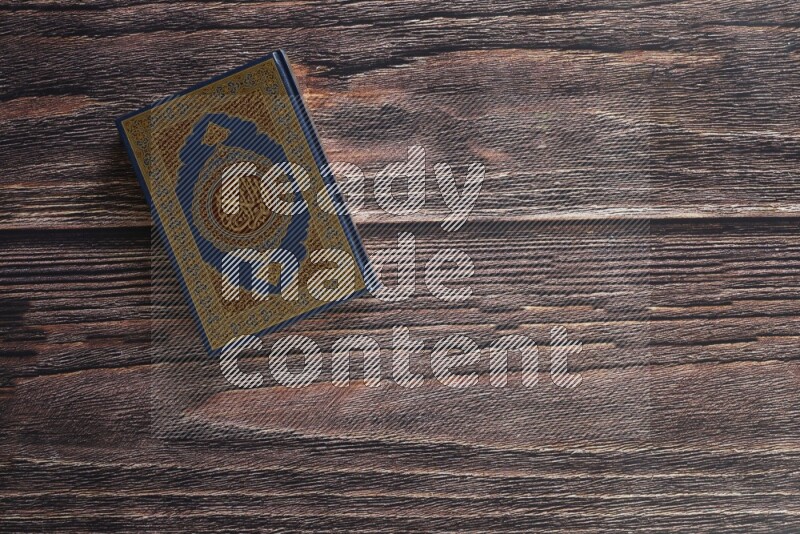 Quran with a prayer beads on wooden background