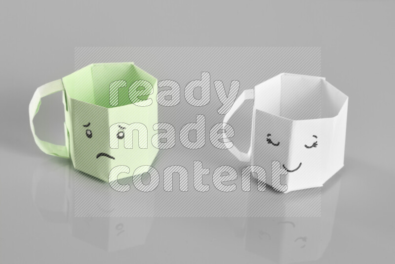 Origami cup on grey background