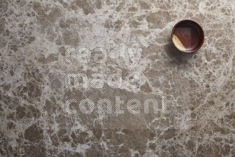 A wooden bowl on beige marble background